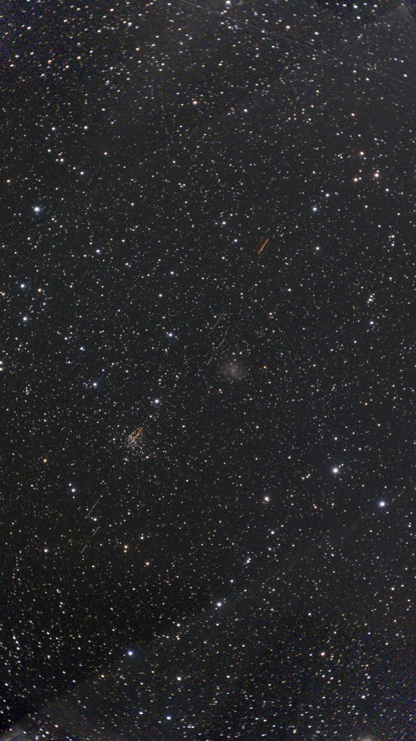 Star field with a faint face-on spiral galaxy near the centre and a rich open star cluster below left, crossed by satellite trails
