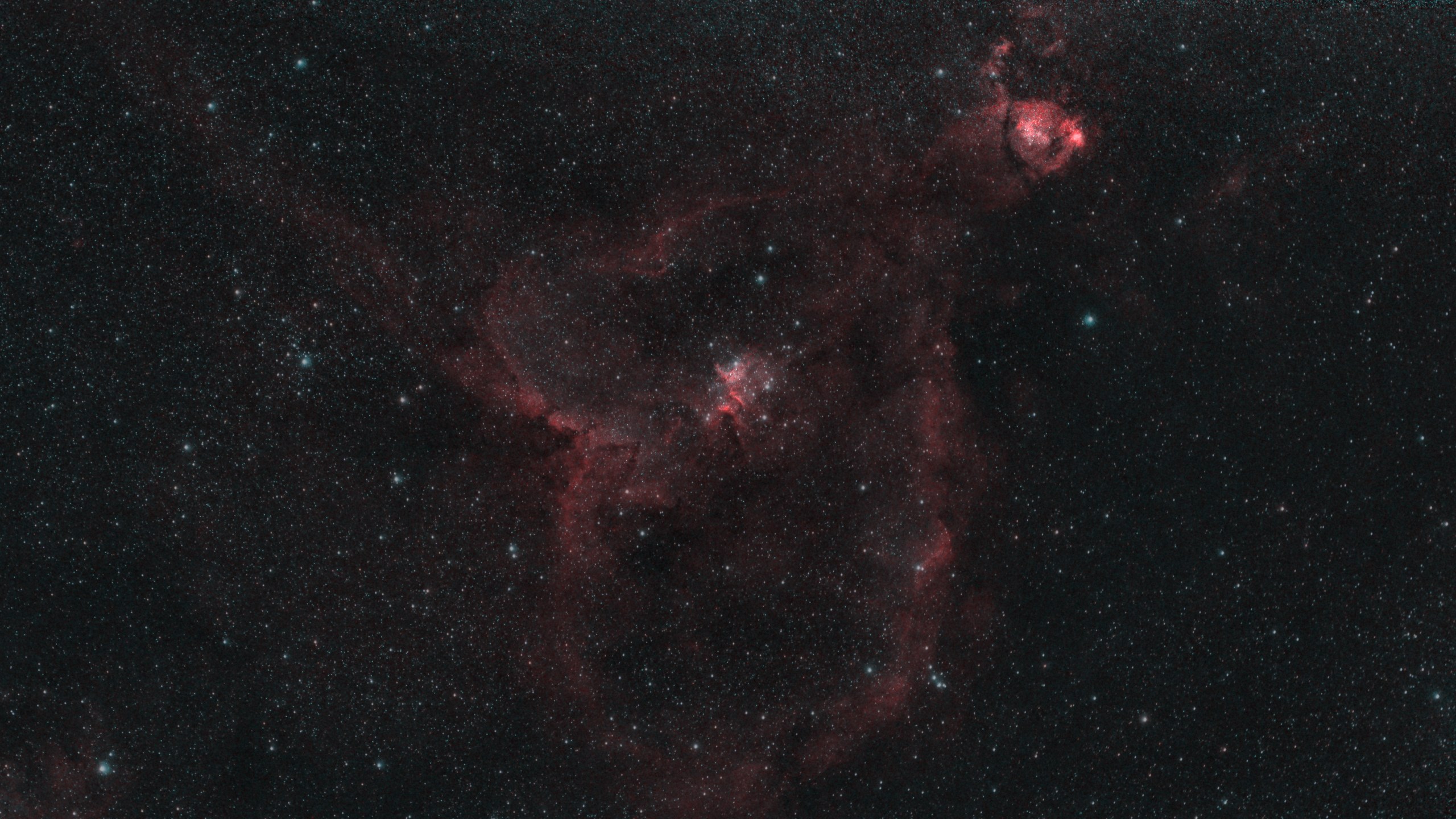 The Heart Nebula, a heart-shaped shell of glowing hydrogen with a young star cluster at its centre and the Fish Head Nebula above
