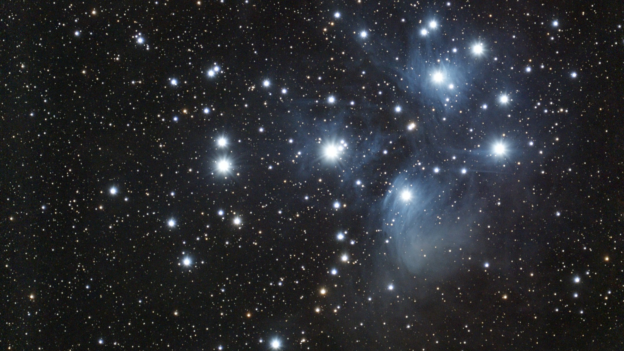 The Pleiades star cluster, blue stars wrapped in reflection nebula
